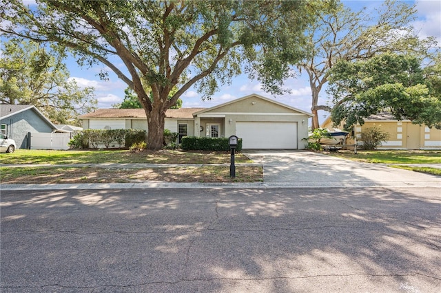 ranch-style house featuring a garage, concrete driveway, and stucco siding