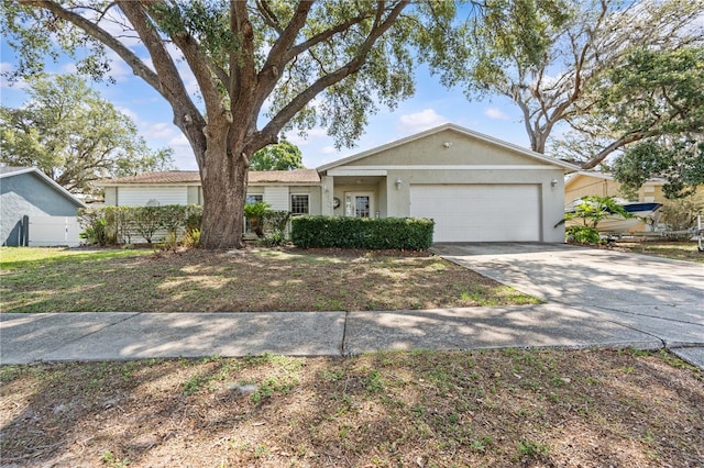 ranch-style home with a garage, driveway, and stucco siding
