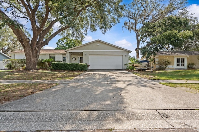 single story home featuring an attached garage, driveway, and stucco siding
