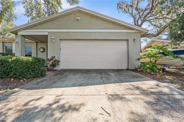 view of front of property with stucco siding, driveway, and an attached garage
