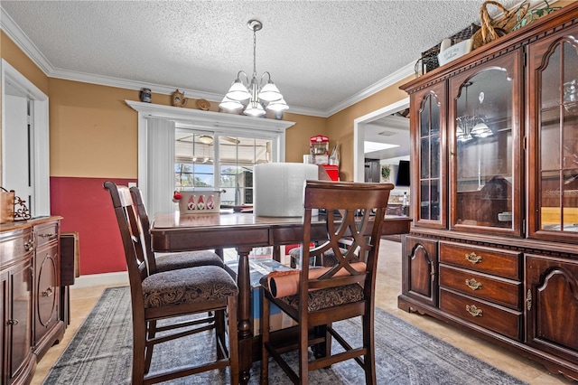 dining room with a chandelier, ornamental molding, and a textured ceiling