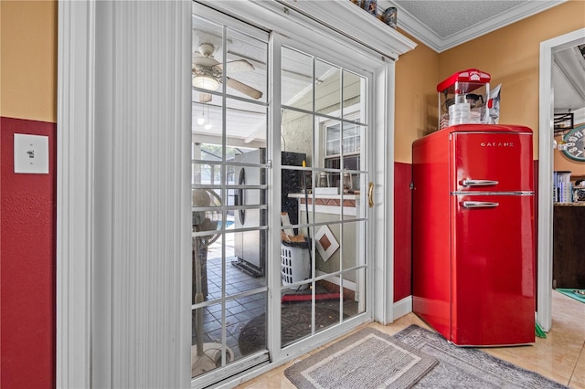 doorway to outside featuring tile patterned floors, crown molding, and ceiling fan