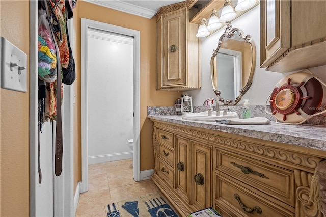 bathroom featuring vanity, tile patterned floors, toilet, baseboards, and ornamental molding