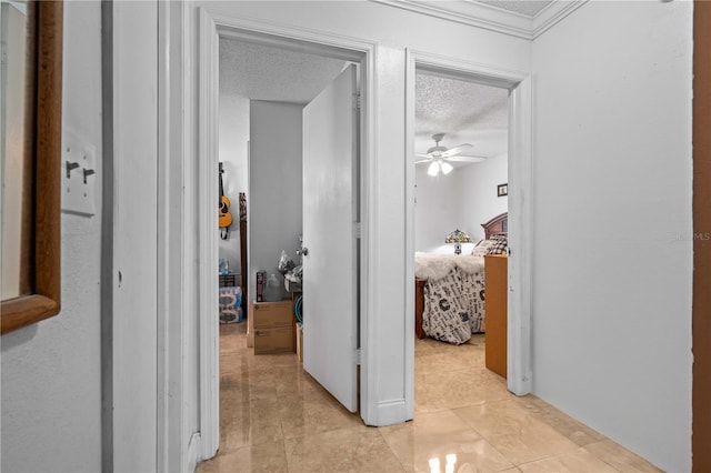hall featuring ornamental molding, a textured ceiling, and light tile patterned flooring