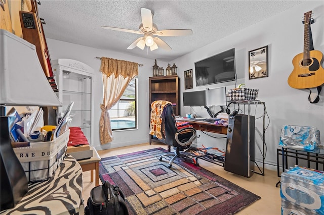 office area featuring a textured ceiling, a ceiling fan, and baseboards