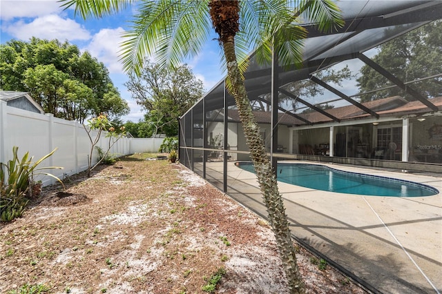 view of pool with a fenced backyard, a patio, and glass enclosure