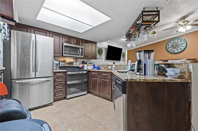 kitchen with stainless steel appliances, light tile patterned flooring, a peninsula, dark brown cabinets, and crown molding