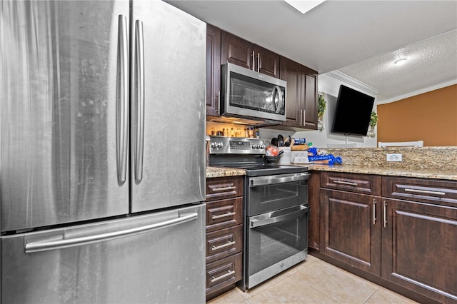 kitchen featuring appliances with stainless steel finishes, light tile patterned floors, a textured ceiling, dark brown cabinetry, and light stone countertops
