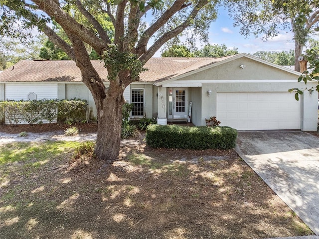 ranch-style house featuring stucco siding, an attached garage, and concrete driveway