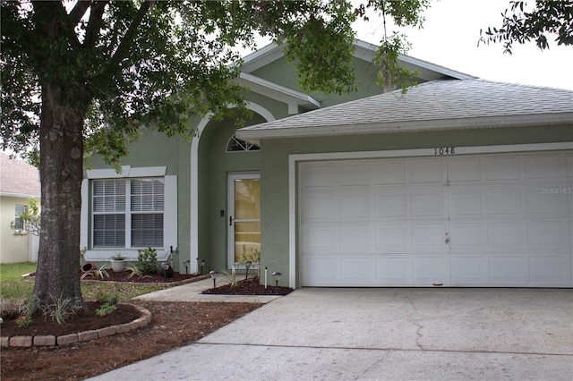 1048 Winding Water Way, Clermont, FL 34714 - view of front of home featuring driveway, an attached garage, a shingled roof, and stucco siding