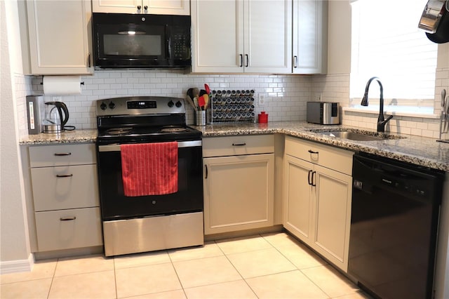 1048 Winding Water Way, Clermont, FL 34714 - kitchen with black appliances, a sink, backsplash, light stone countertops, and light tile patterned flooring