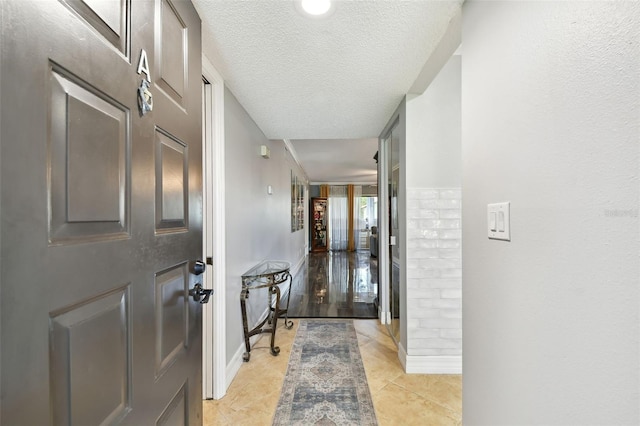 1801 E Lake Rd Unit 3A, Palm Harbor, FL 34685 - foyer featuring a textured ceiling, baseboards, and light tile patterned floors
