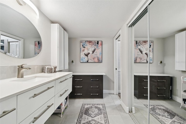 1801 E Lake Rd Unit 3A, Palm Harbor, FL 34685 - full bath with vanity, baseboards, a textured ceiling, tile patterned floors, and a closet