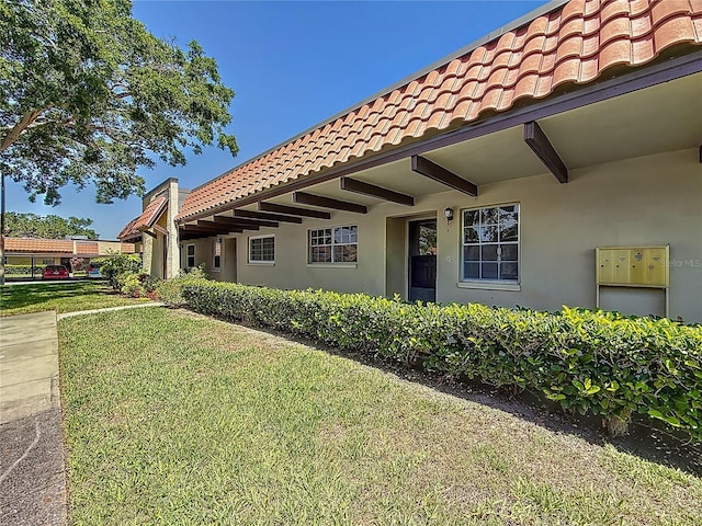 1701 Pinehurst Rd Unit 16C, Dunedin, FL 34698 - entrance to property featuring a tile roof, stucco siding, and a yard