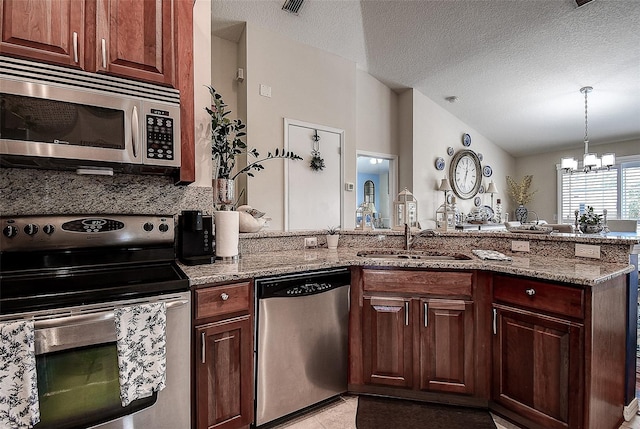 kitchen with appliances with stainless steel finishes, a sink, a chandelier, light stone countertops, and vaulted ceiling