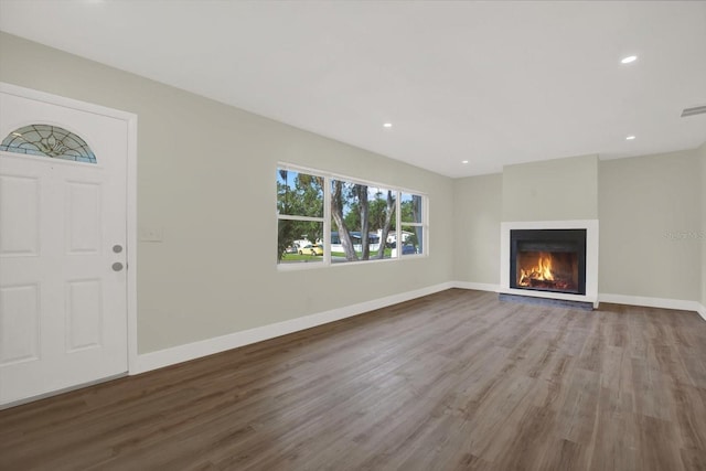 1352 Parkwood St, Clearwater, FL 33755 - unfurnished living room with wood finished floors, baseboards, a glass covered fireplace, and recessed lighting