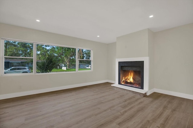 1352 Parkwood St, Clearwater, FL 33755 - unfurnished living room with wood finished floors, a warm lit fireplace, recessed lighting, and baseboards