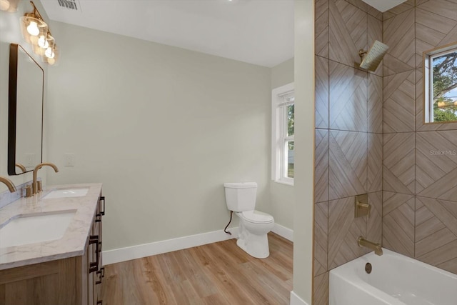 1352 Parkwood St, Clearwater, FL 33755 - full bath with wood finished floors, healthy amount of natural light, baseboards, and toilet