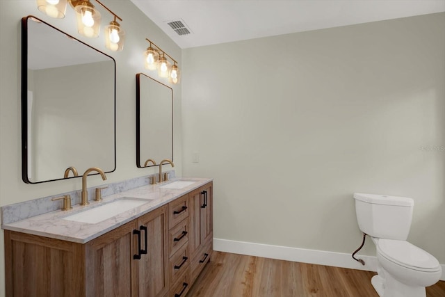 1352 Parkwood St, Clearwater, FL 33755 - bathroom featuring baseboards, wood finished floors, toilet, and double vanity