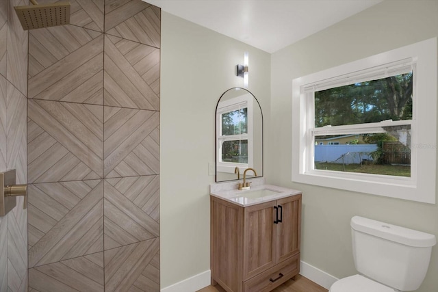 1352 Parkwood St, Clearwater, FL 33755 - bathroom with vanity, toilet, baseboards, and tiled shower