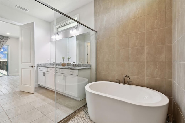 8421 Ivy Stark Blvd, Wesley Chapel, FL 33545 - full bath featuring tile walls, double vanity, a soaking tub, and tile patterned floors