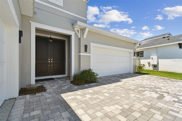 8421 Ivy Stark Blvd, Wesley Chapel, FL 33545 - doorway to property with stucco siding, decorative driveway, and a garage