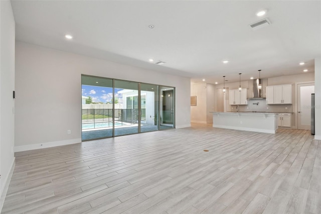 8421 Ivy Stark Blvd, Wesley Chapel, FL 33545 - unfurnished living room with light wood-style flooring, recessed lighting, and baseboards
