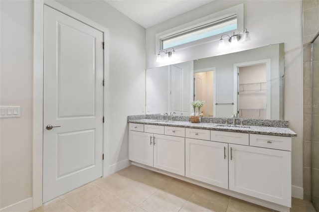 8421 Ivy Stark Blvd, Wesley Chapel, FL 33545 - full bath featuring double vanity, tile patterned floors, baseboards, and a tile shower