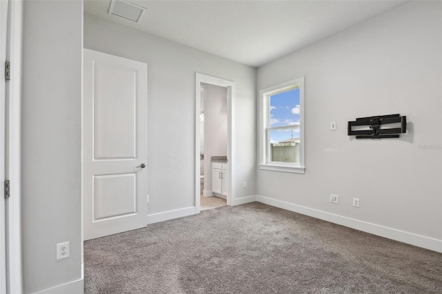 8421 Ivy Stark Blvd, Wesley Chapel, FL 33545 - unfurnished bedroom featuring baseboards, carpet floors, and connected bathroom