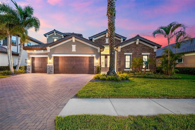 1416 Via Verdi Dr, Palm Harbor, FL 34683 - view of front facade featuring stone siding, an attached garage, decorative driveway, stucco siding, and a lawn