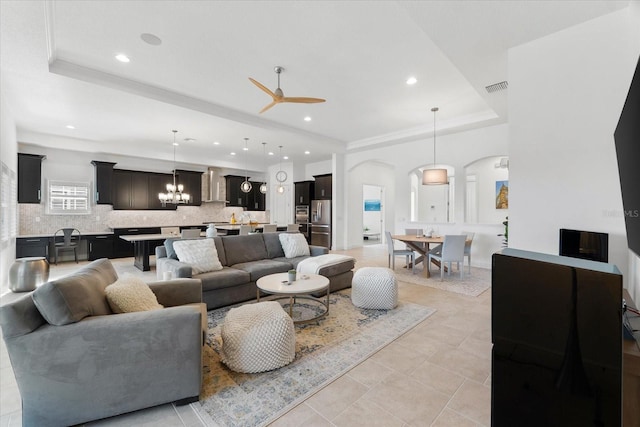 1416 Via Verdi Dr, Palm Harbor, FL 34683 - living area featuring a tray ceiling, a ceiling fan, arched walkways, recessed lighting, and a chandelier