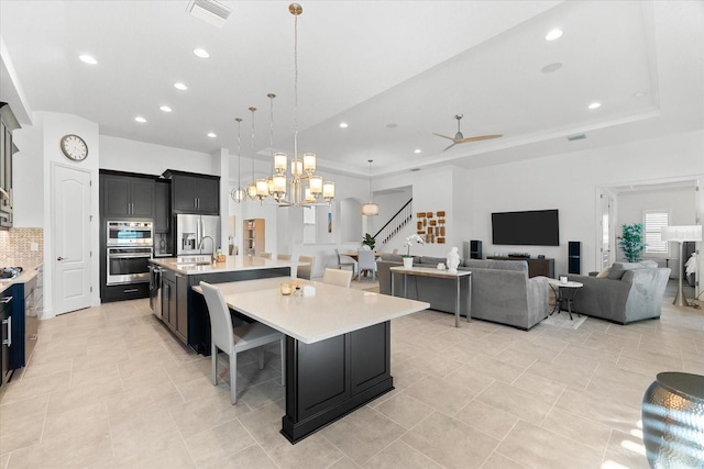 1416 Via Verdi Dr, Palm Harbor, FL 34683 - kitchen featuring light countertops, stainless steel appliances, decorative backsplash, a spacious island, and open floor plan