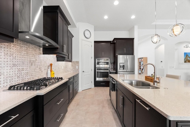 1416 Via Verdi Dr, Palm Harbor, FL 34683 - kitchen featuring stainless steel appliances, wall chimney exhaust hood, backsplash, arched walkways, and a center island with sink
