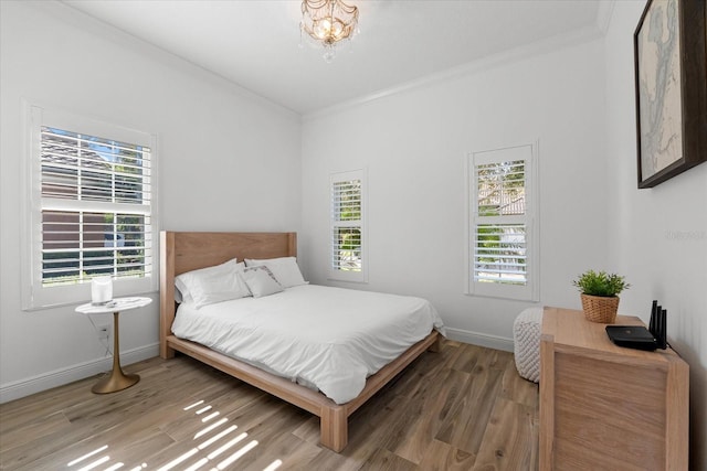 1416 Via Verdi Dr, Palm Harbor, FL 34683 - bedroom with wood finished floors, crown molding, and a chandelier