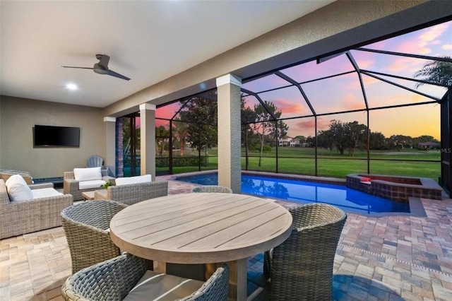 1416 Via Verdi Dr, Palm Harbor, FL 34683 - patio terrace at dusk featuring a patio, ceiling fan, a pool with connected hot tub, outdoor lounge area, and a lanai