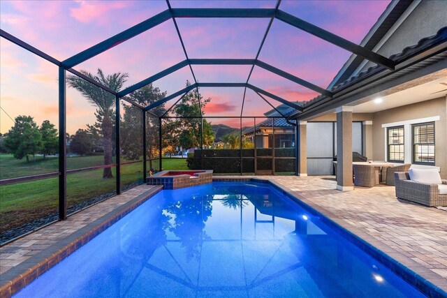1416 Via Verdi Dr, Palm Harbor, FL 34683 - pool at dusk with a patio area, a pool with connected hot tub, and glass enclosure