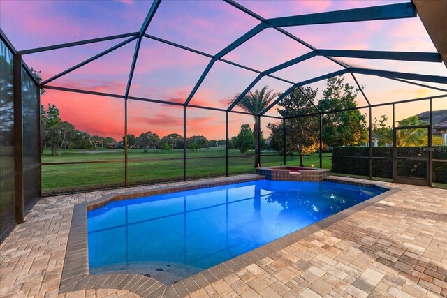 1416 Via Verdi Dr, Palm Harbor, FL 34683 - pool at dusk featuring a patio, a pool with connected hot tub, a lanai, and a yard