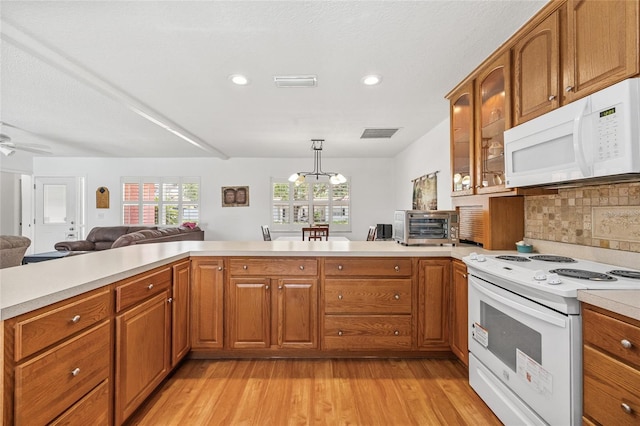 603 Royal Crest Dr, Brandon, FL 33511 - kitchen featuring white appliances, light countertops, light wood-style floors, brown cabinetry, and recessed lighting