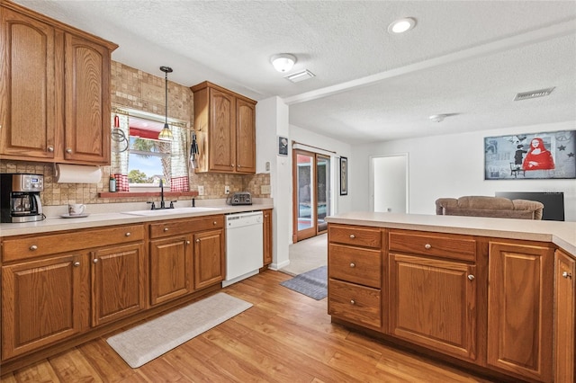 603 Royal Crest Dr, Brandon, FL 33511 - kitchen with white dishwasher, a sink, brown cabinets, light countertops, and a textured ceiling