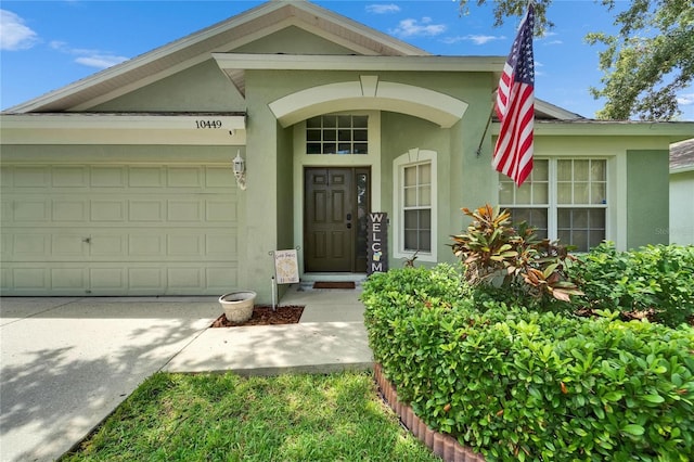 10449 Hunters Haven Blvd, Riverview, FL 33578 - property entrance featuring stucco siding, an attached garage, and driveway