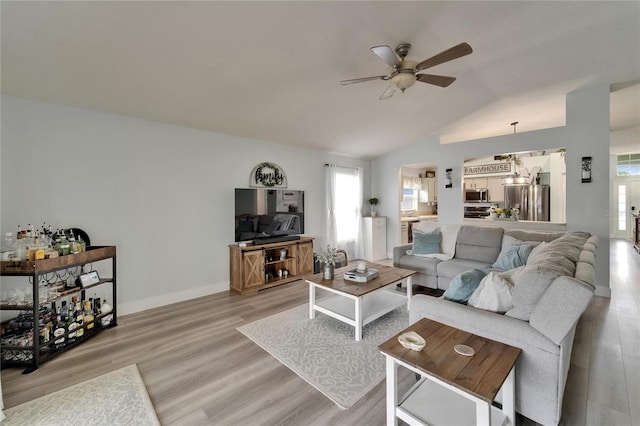 10449 Hunters Haven Blvd, Riverview, FL 33578 - living room with a ceiling fan, healthy amount of natural light, vaulted ceiling, light wood finished floors, and baseboards