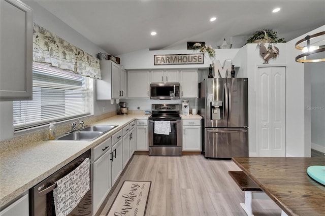 10449 Hunters Haven Blvd, Riverview, FL 33578 - kitchen featuring stainless steel appliances, a sink, lofted ceiling, light countertops, and light wood-type flooring