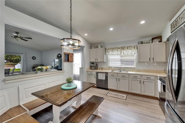 10449 Hunters Haven Blvd, Riverview, FL 33578 - kitchen featuring stainless steel appliances, a sink, lofted ceiling, light countertops, and light wood finished floors