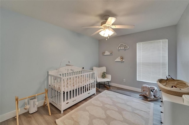 10449 Hunters Haven Blvd, Riverview, FL 33578 - bedroom featuring a nursery area, wood finished floors, baseboards, and ceiling fan