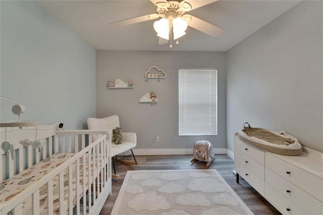 10449 Hunters Haven Blvd, Riverview, FL 33578 - bedroom featuring a nursery area, dark wood-style flooring, baseboards, and ceiling fan