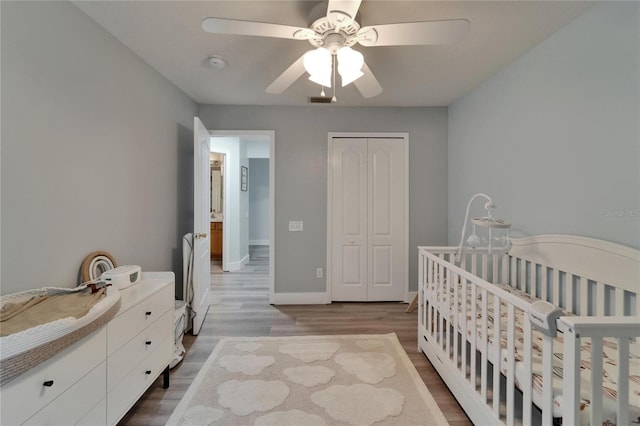 10449 Hunters Haven Blvd, Riverview, FL 33578 - bedroom with wood finished floors, a closet, baseboards, ceiling fan, and a nursery area