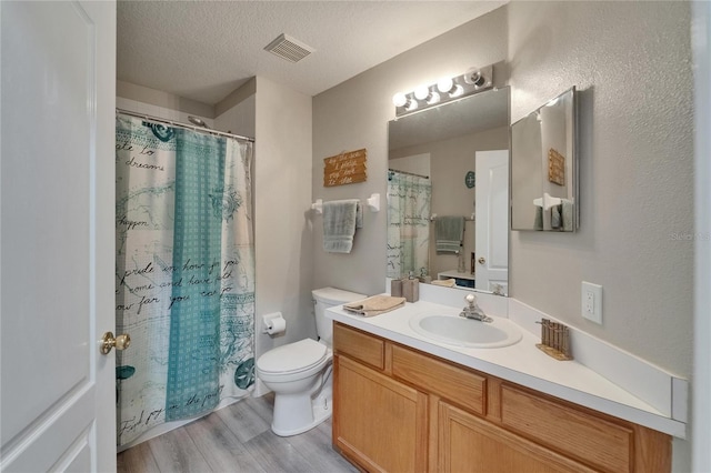 10449 Hunters Haven Blvd, Riverview, FL 33578 - full bath with vanity, wood finished floors, toilet, a textured ceiling, and a shower with curtain