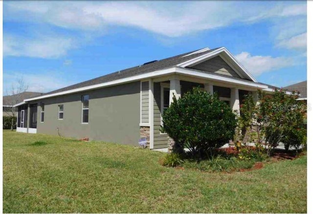 12202 Fairlawn Dr, Riverview, FL 33579 - view of side of property featuring a lawn, a sunroom, and stone siding