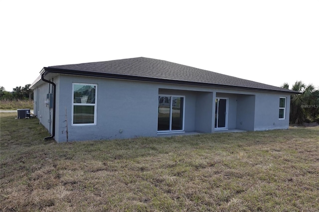 17099 Carleen Ave, Port Charlotte, FL 33948 - back of property with central AC, stucco siding, and a lawn