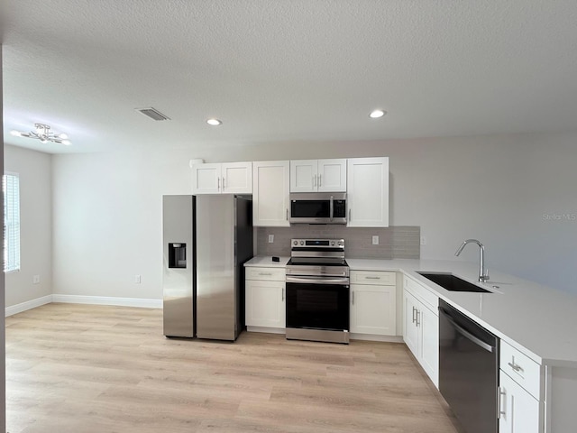 17099 Carleen Ave, Port Charlotte, FL 33948 - kitchen featuring appliances with stainless steel finishes, a sink, decorative backsplash, a peninsula, and light countertops